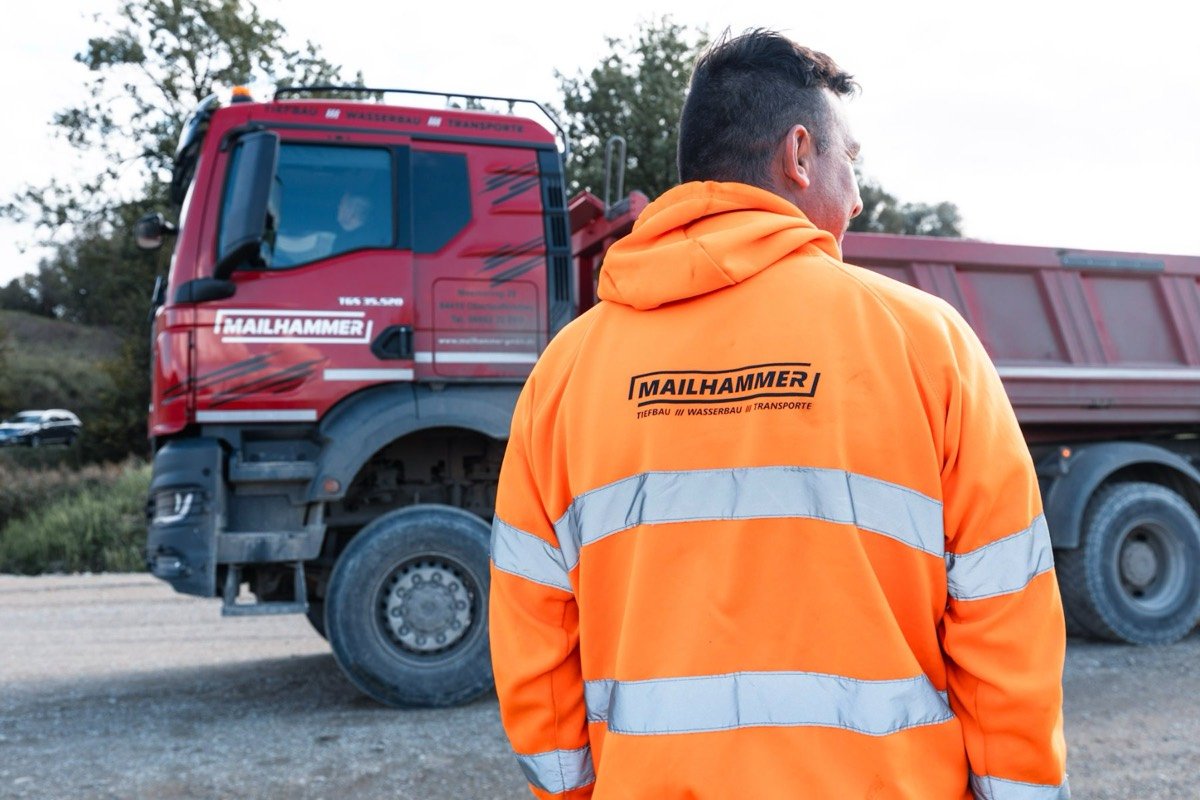 Mailhammer-Mitarbeiter in Warnjacke an einem Kipper