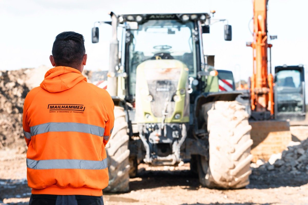 Mailhammer-Mitarbeiter in Warnjacke überblickt die Baustelle